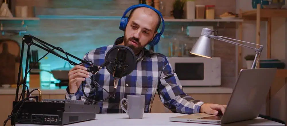Podcaster using all his podcast equipment during a podcast