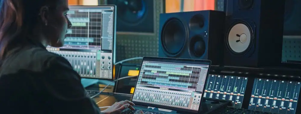 Woman editing a podcast on her laptop using audio editing software