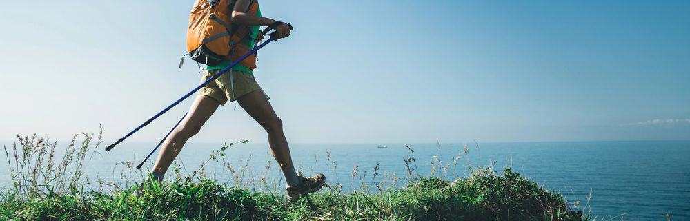 Walking A man walking on a grassy hillside beside the beach on a beautiful day demonstrating the benefits of walking 2 miles a day