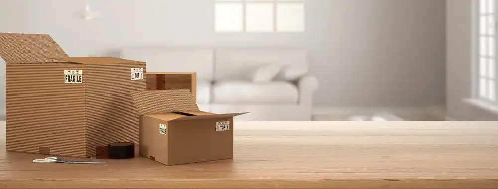 packing boxes stacked ready to move house ready to search for the best places to live to escape the rat race