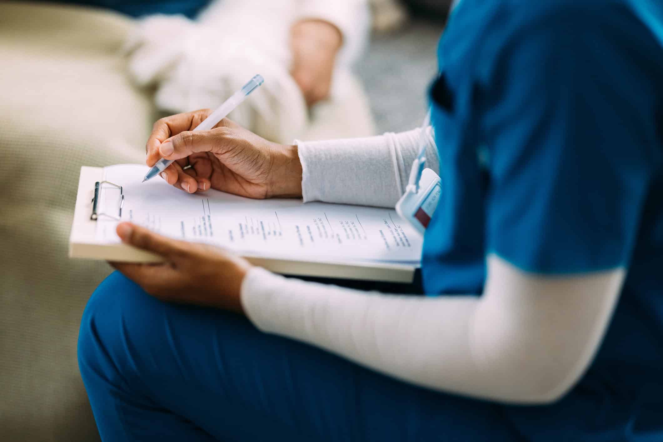 Nurse Taking Notes During a Patient Consultation in Hospital