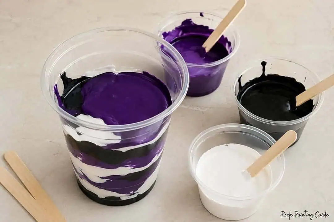 Halloween Paint Pouring on Rocks: Easy Acrylic Pour Tutorial 7 Black, purple, and white acrylic paint layered in a clear cup for a Halloween dirty pour