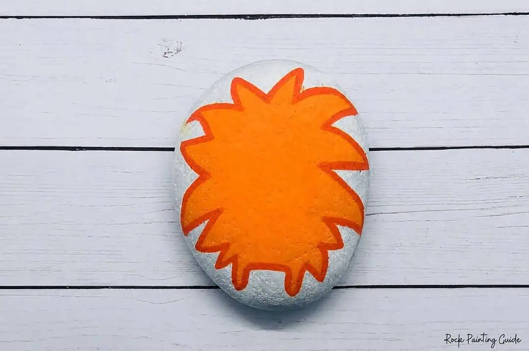 Easy Monster Rock Painting Tutorial: Fuzzy Halloween Rocks 5 outline the monster rock painting with a darker orange