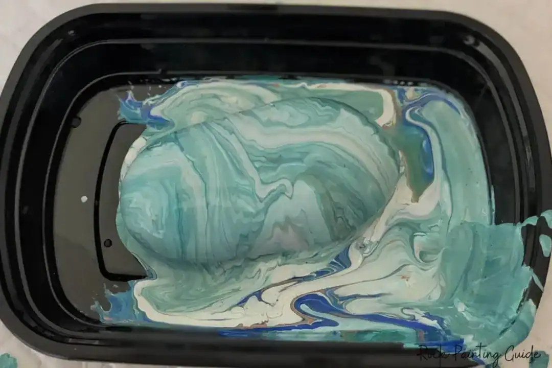 Beginner’s Guide to Paint Pouring on Rocks (With No-Fail Tips!) 17 teal paint pour on rock