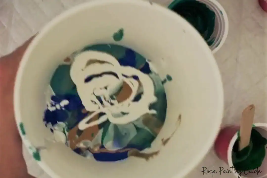 Beginner’s Guide to Paint Pouring on Rocks (With No-Fail Tips!) 15 paint layered in a cup for a dirty pour