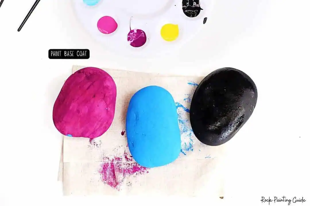 Easy Starry Night Sky Galaxy Painted Rocks for Beginners 5 Brightly colored rocks with paint palette and brushes, perfect for rock painting art projects.