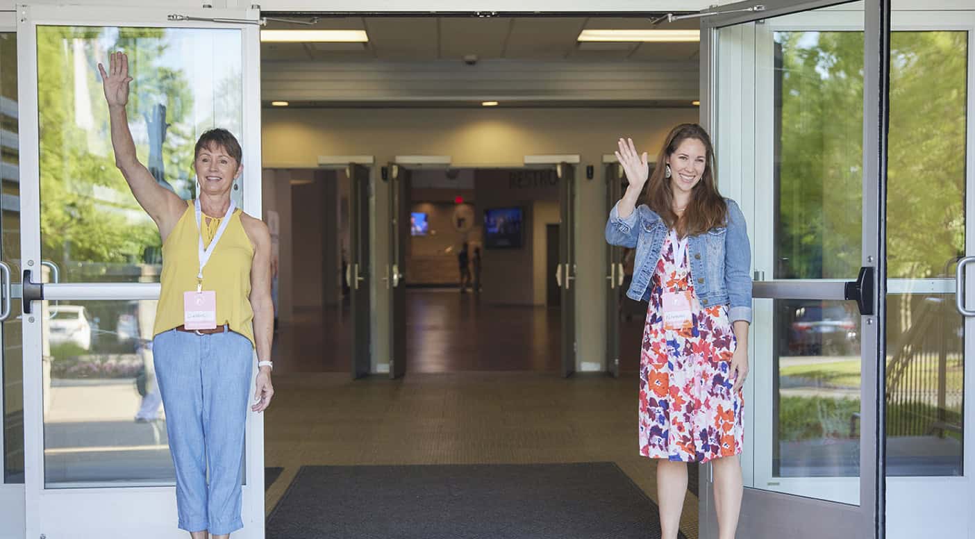 Friendly women greeting at Rolling Hills Community Church entrance.