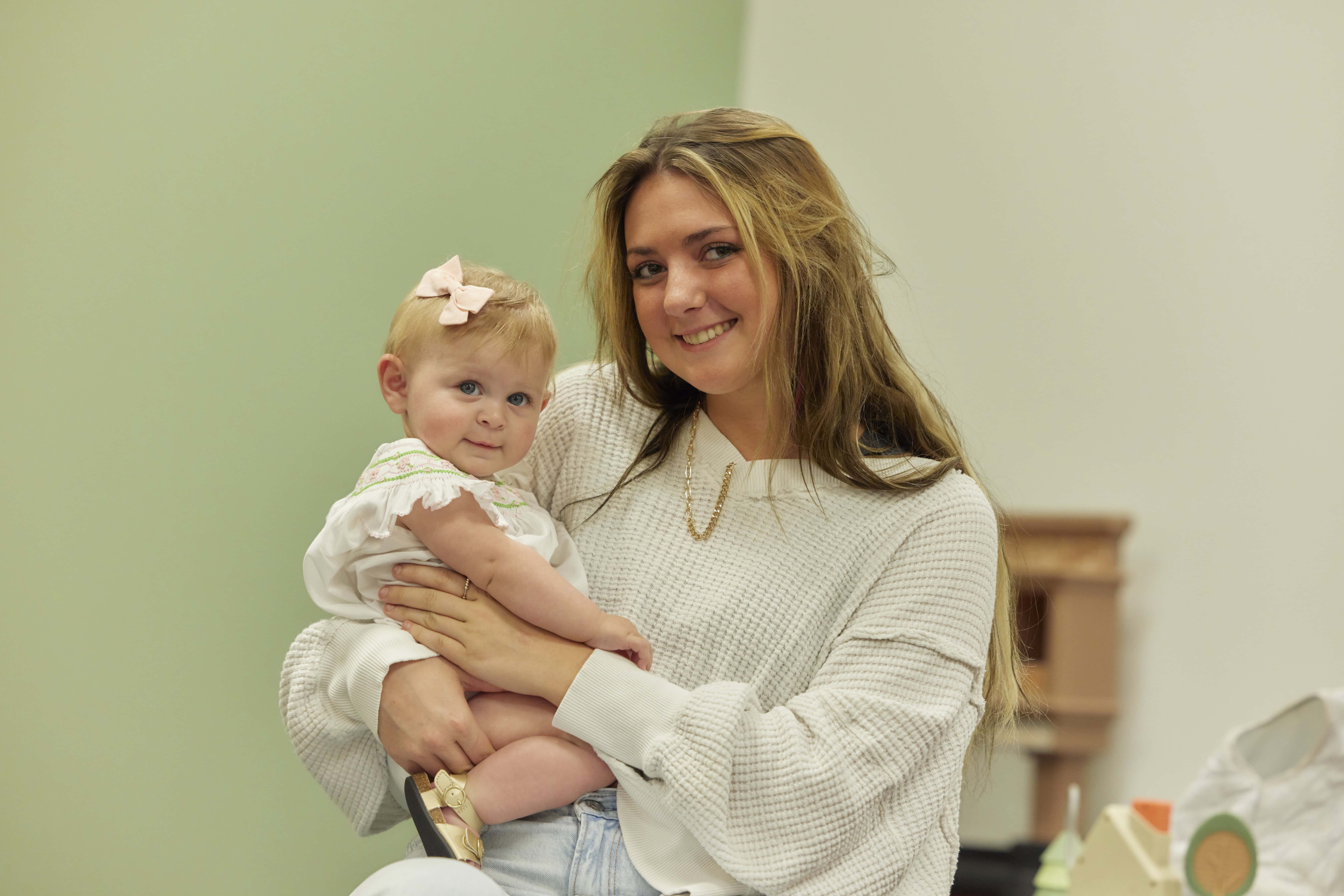 Happy woman holding a baby girl at Rolling Hills Community Church event.