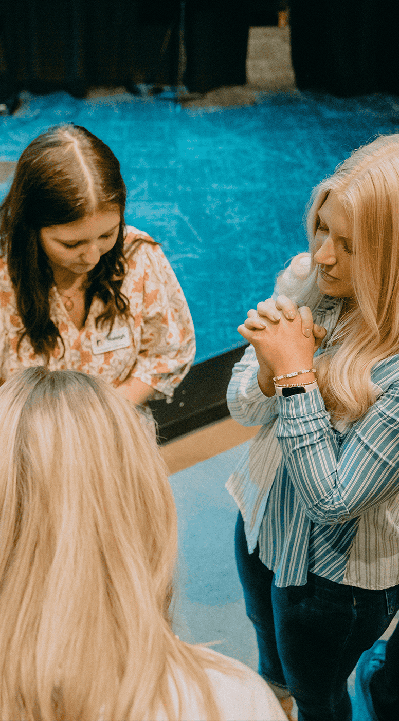 Women praying together during community worship at Rolling Hills Church.