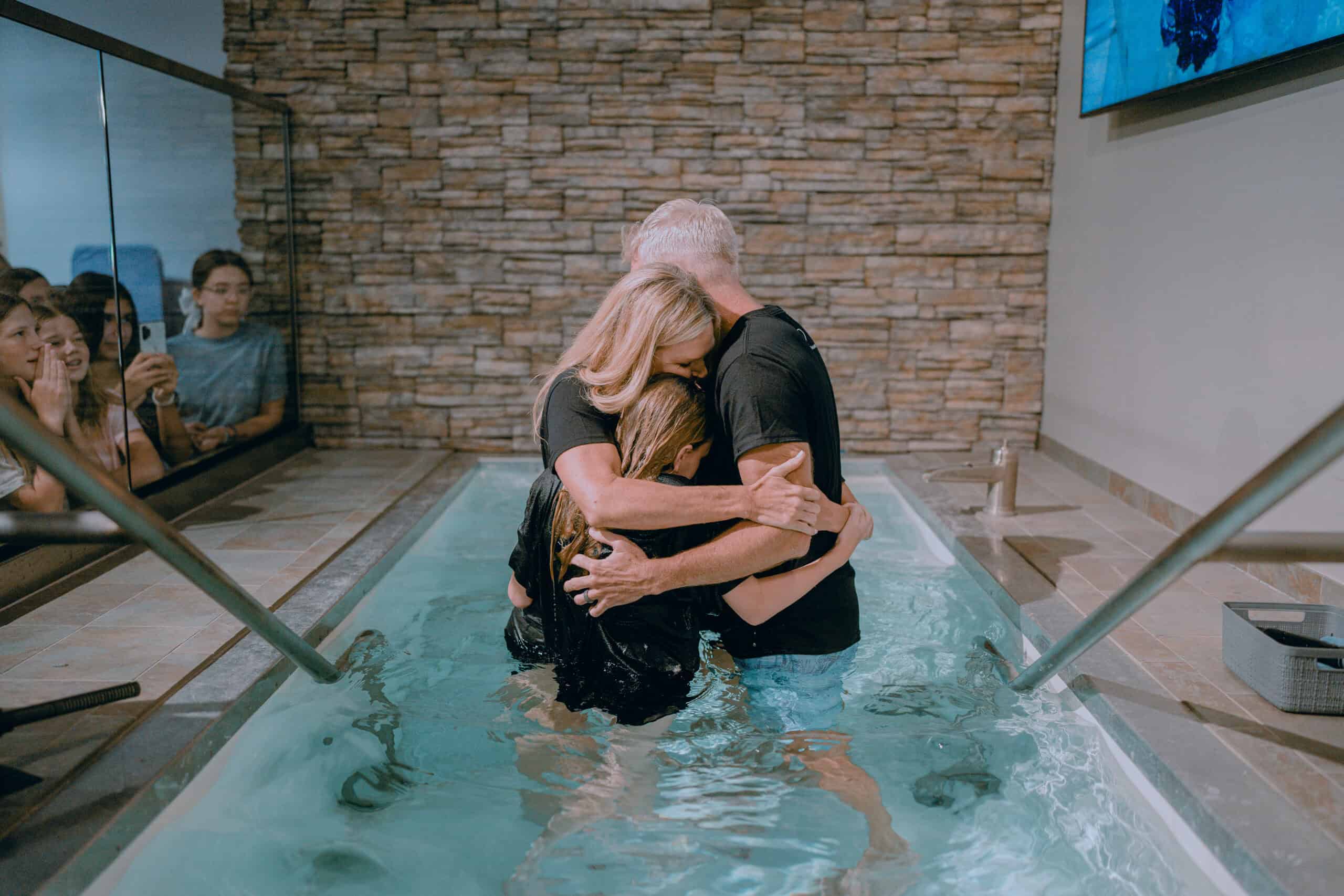People being baptized in water during a church baptism ceremony.
