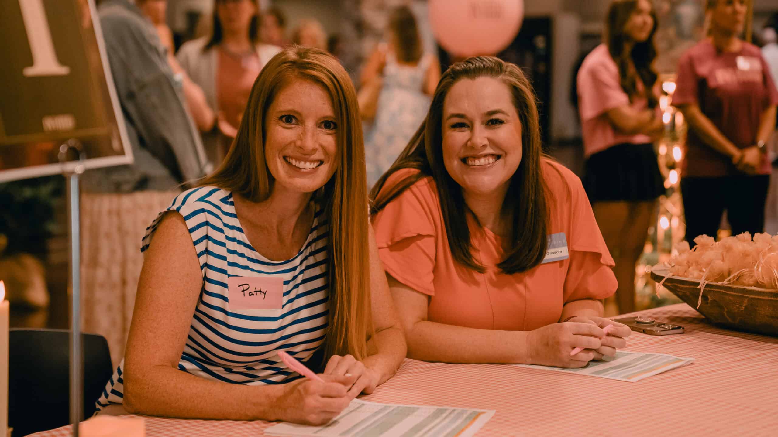 Two smiling women at Rolling Hills Community Church event, engaging with attendees.