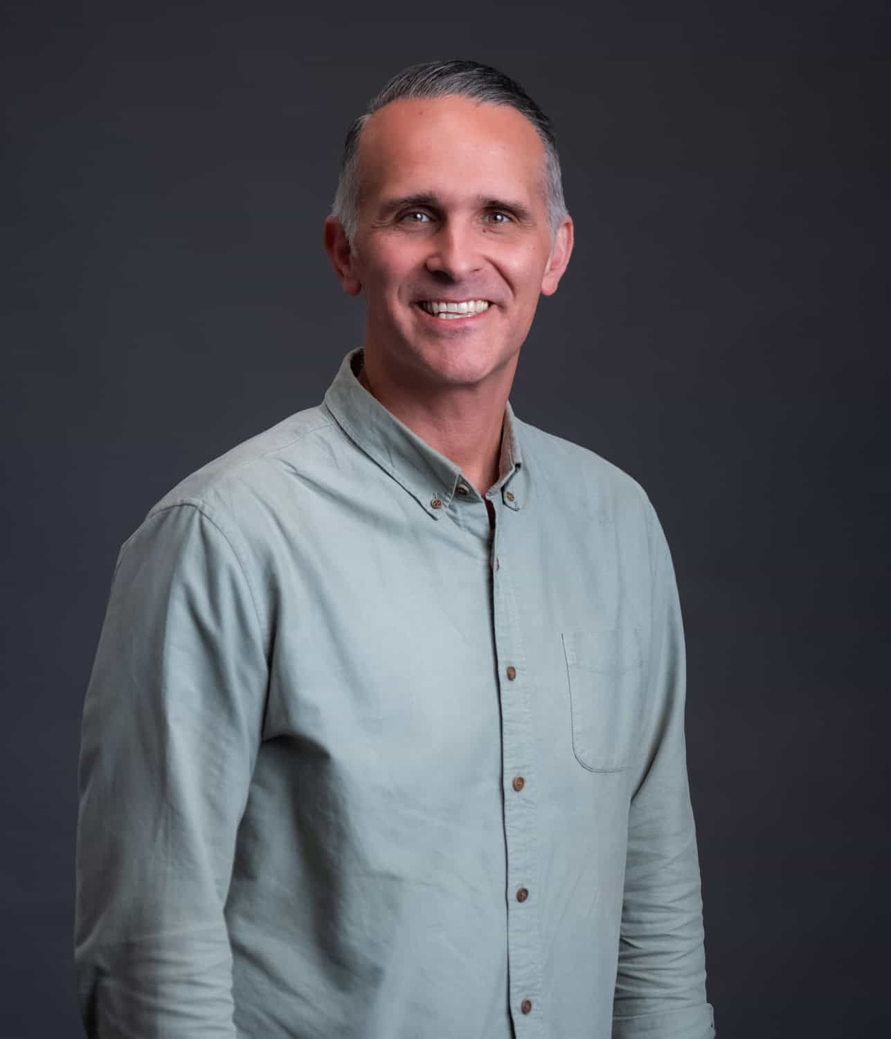 Community pastor smiling, standing confidently at Rolling Hills Community Church.