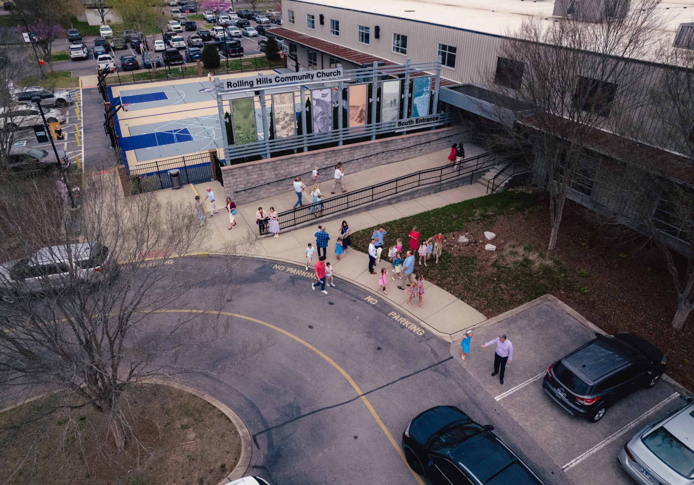 Exterior view of Rolling Hills Community Church with outdoor sports courts and visitors.