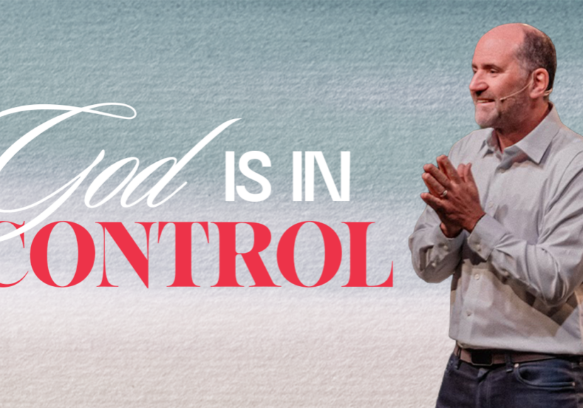 Inspirational church image with a speaker emphasizing that God is in control of all situations.