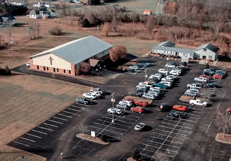 Parking lot at Rolling Hills Community Church with ample spaces and surrounding natural landscape.