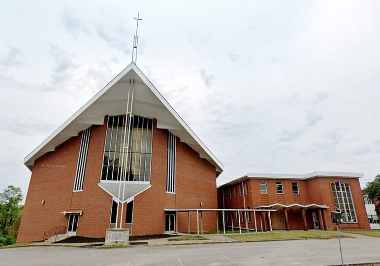 Church building with brick exterior, tall steeple, and modern architecture at Rolling Hills Communit.