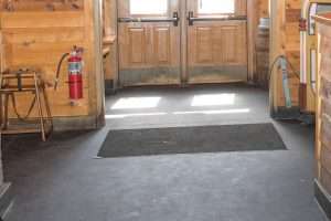 Entrance with wooden doors and fire extinguisher inside a rustic building.