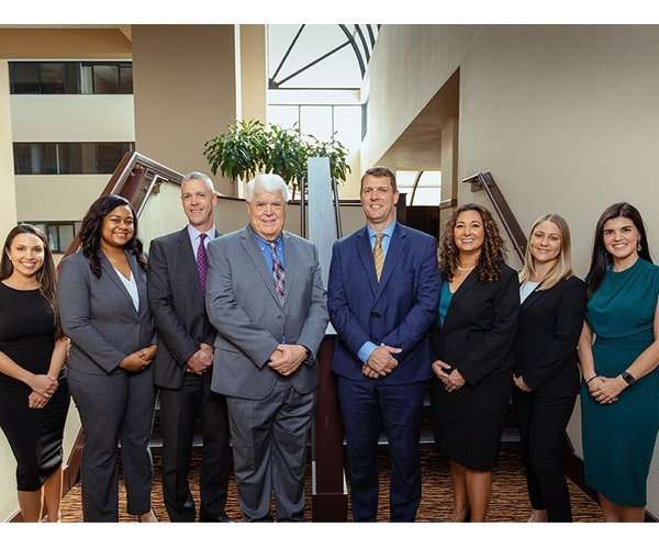 Romano Law Group team of attorneys and staff in professional attire at office.