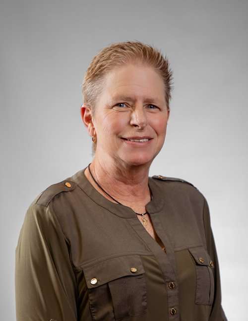 Professional woman in military-style uniform smiling for Romano Law Group.
