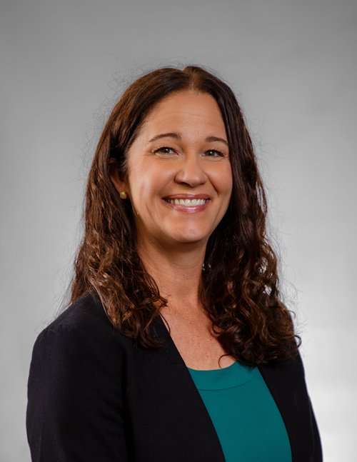 Professional woman in business attire smiling for Romano Law Group image.
