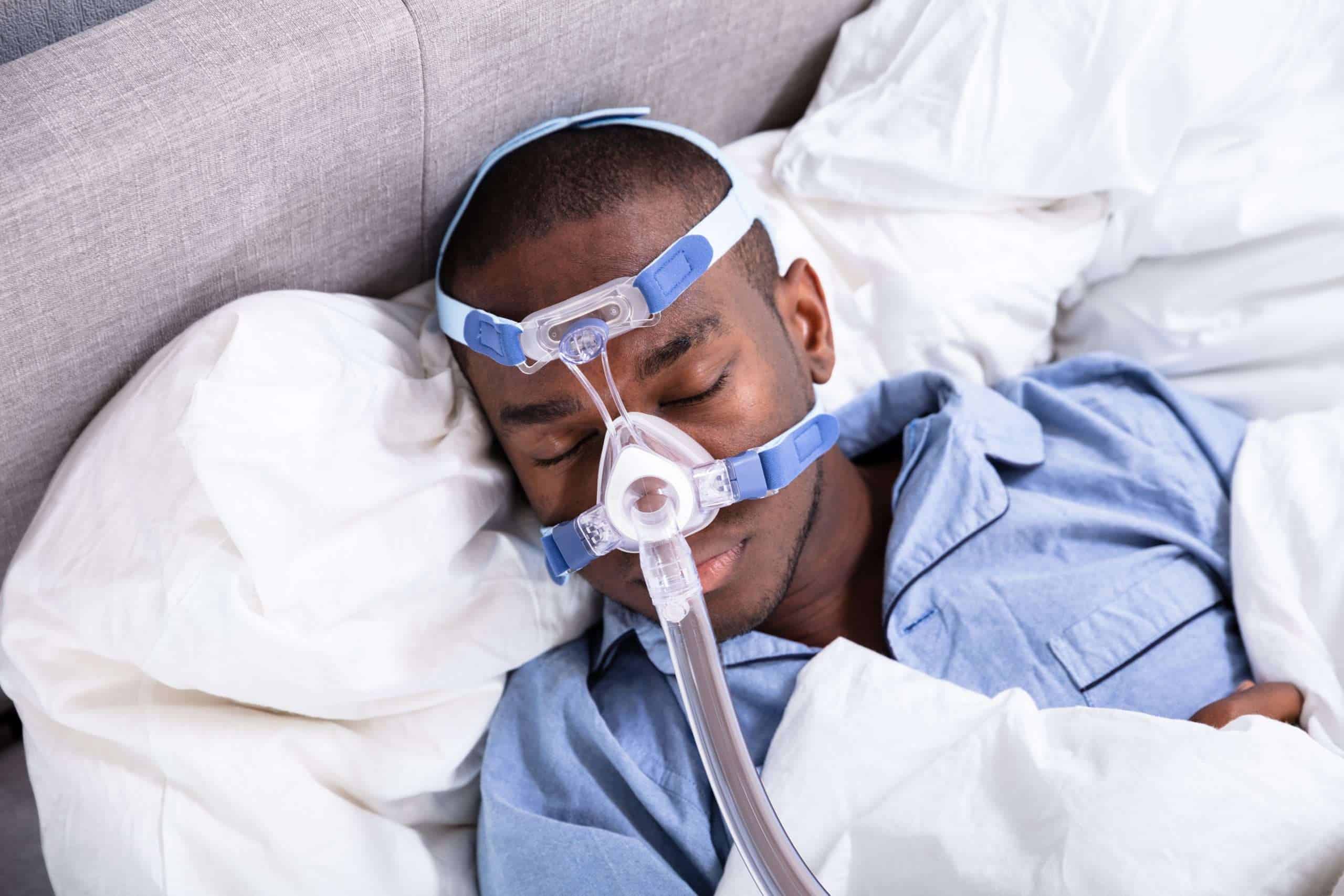 Man with oxygen mask resting in bed, medical care and health concept.