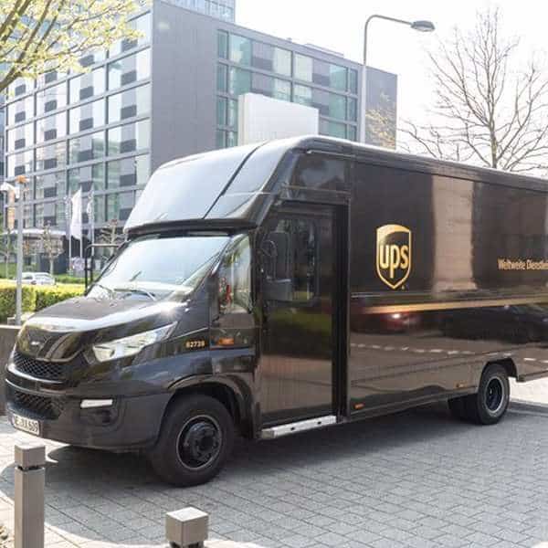 UPS delivery truck parked on city street near modern office buildings.