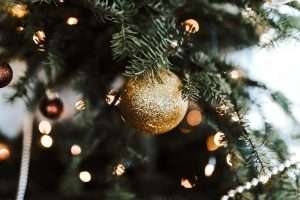 Close-up of a decorated Christmas tree with gold ornaments and lights.