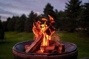Campfire with burning logs outdoors during evening or dusk.