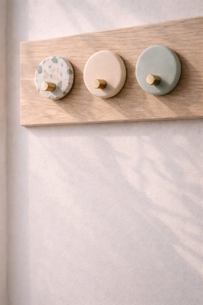 modern wall hooks with decorative polymer clay front in neutral tones, mounted on light wood wall panel