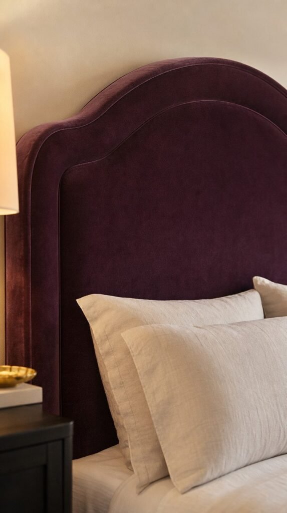 Velvet plum upholstered headboard with cream linen pillows -Plum Noir Bedroom Ideas