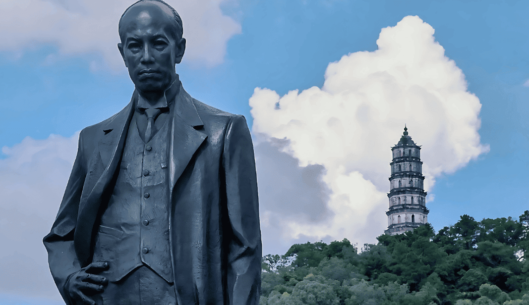 Statue of Liang Qichao in Xinhui with a historical pagoda in the background.