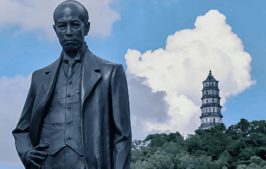 Statue of Liang Qichao in Xinhui with a historical pagoda in the background.