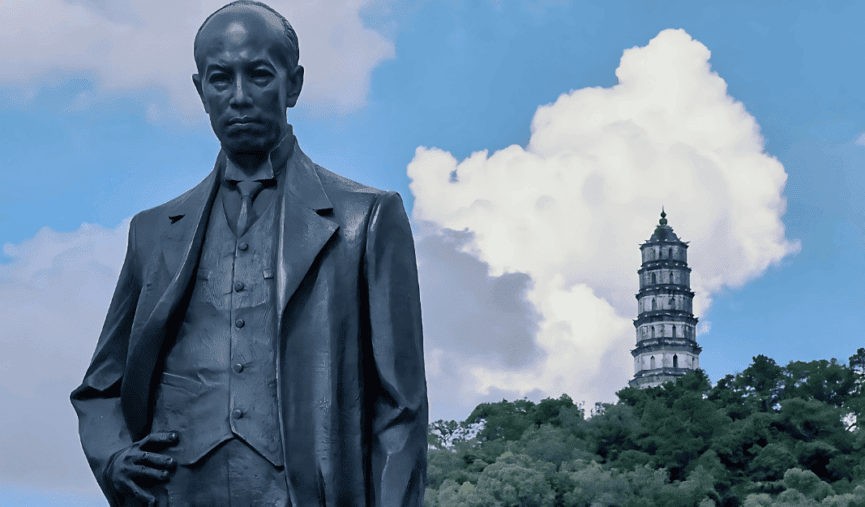 Statue of Liang Qichao in Xinhui with a historical pagoda in the background.