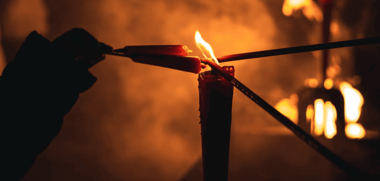 Lighting incense sticks from a candle flame during modern ancestor worship practices.
