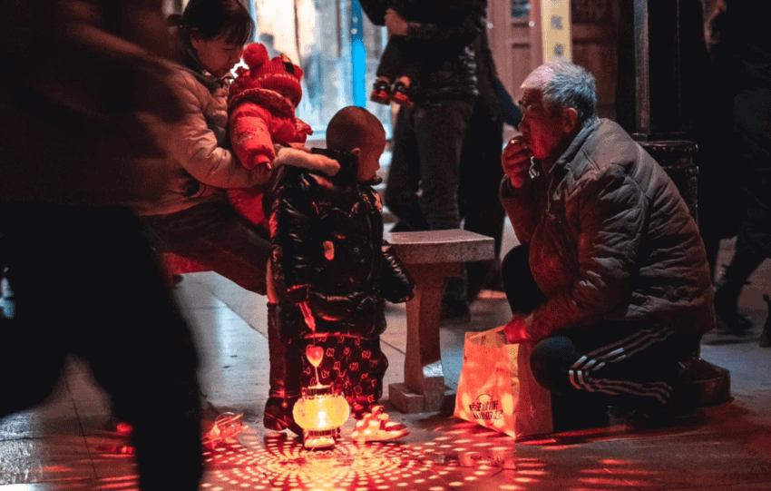 Family gathering around a glowing lantern, symbolizing modern ancestor worship practices in a communal setting.