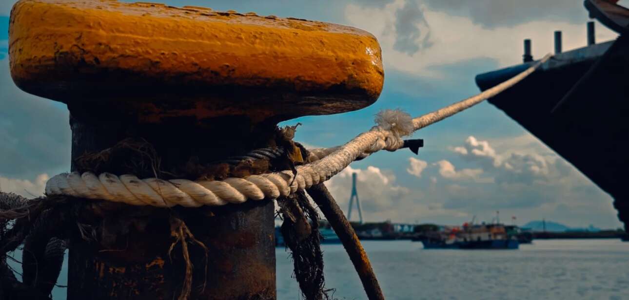 A docked ship with mooring ropes, symbolizing the perilous sea voyages undertaken by Chinese labor migrants after the end of slavery.