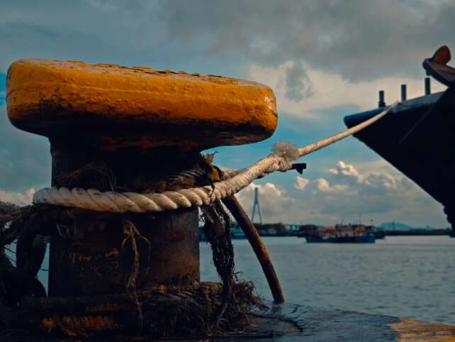 A docked ship with mooring ropes, symbolizing the perilous sea voyages undertaken by Chinese labor migrants after the end of slavery.