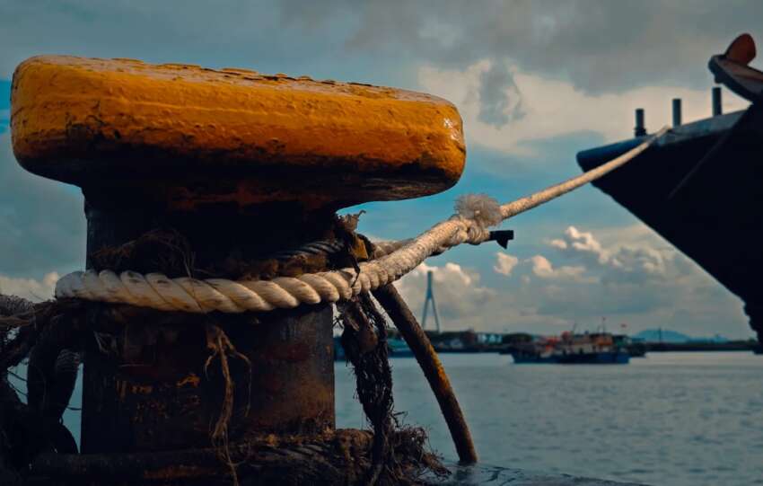 A docked ship with mooring ropes, symbolizing the perilous sea voyages undertaken by Chinese labor migrants after the end of slavery.