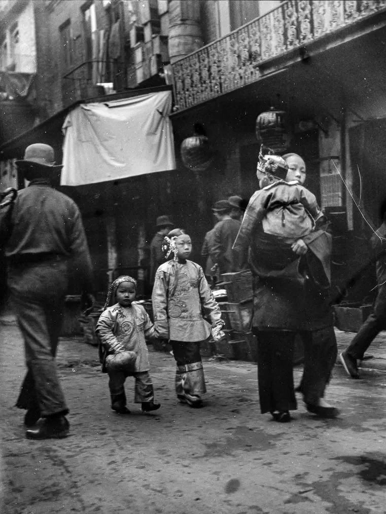 A historical photograph of Chinese families walking through San Francisco’s Chinatown, representing the preservation of the Siyi dialect among Wuyi migrants.
