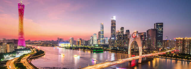 A vibrant sunset over Guangzhou’s skyline featuring the Canton Tower and modern skyscrapers, representing the economic growth of the Siyi Greater Bay Area Development.