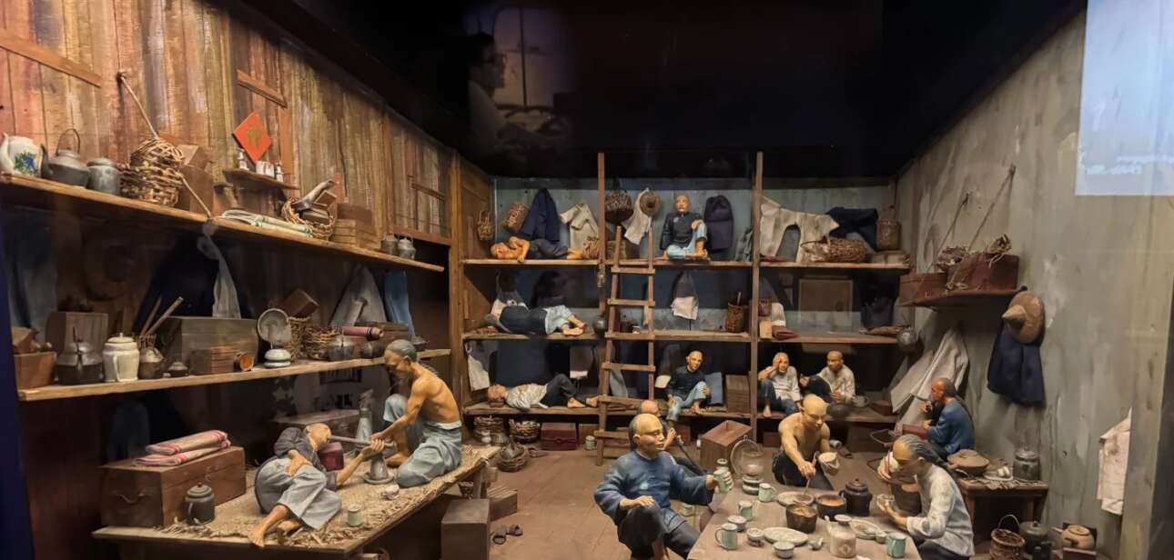 Historical photograph showing Heshan migrants in Singapore during the early 20th century, with traditional Chinese architecture in the background