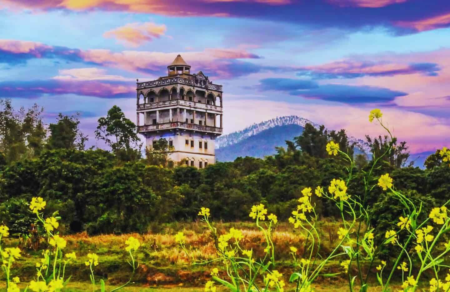 A Kaiping diaolou watchtower rising above village rooftops, a UNESCO World Heritage structure built with overseas remittance money bearing surname signatures