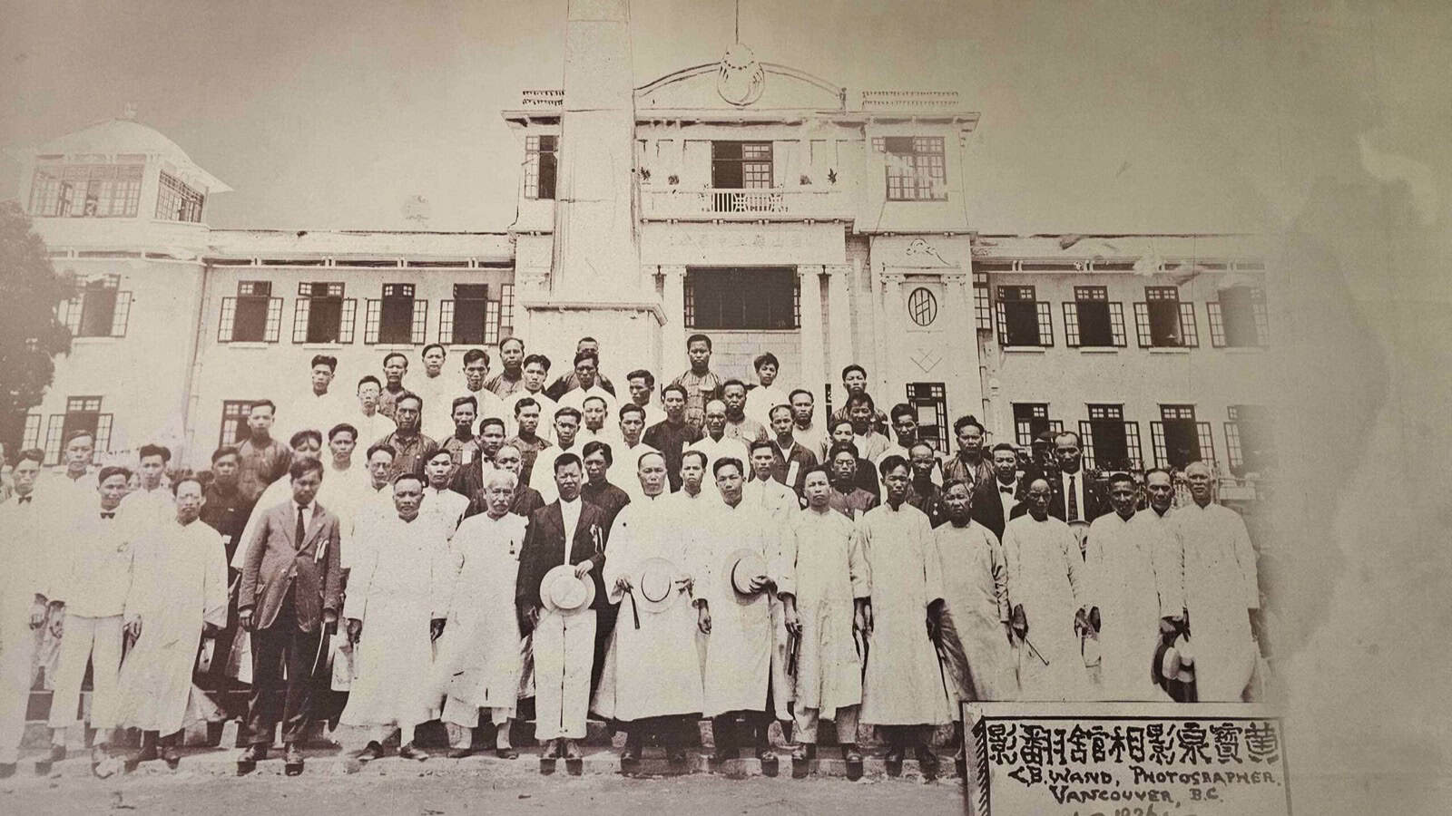 A Wuyi diaspora community gathering, people seated together at a long banquet table.