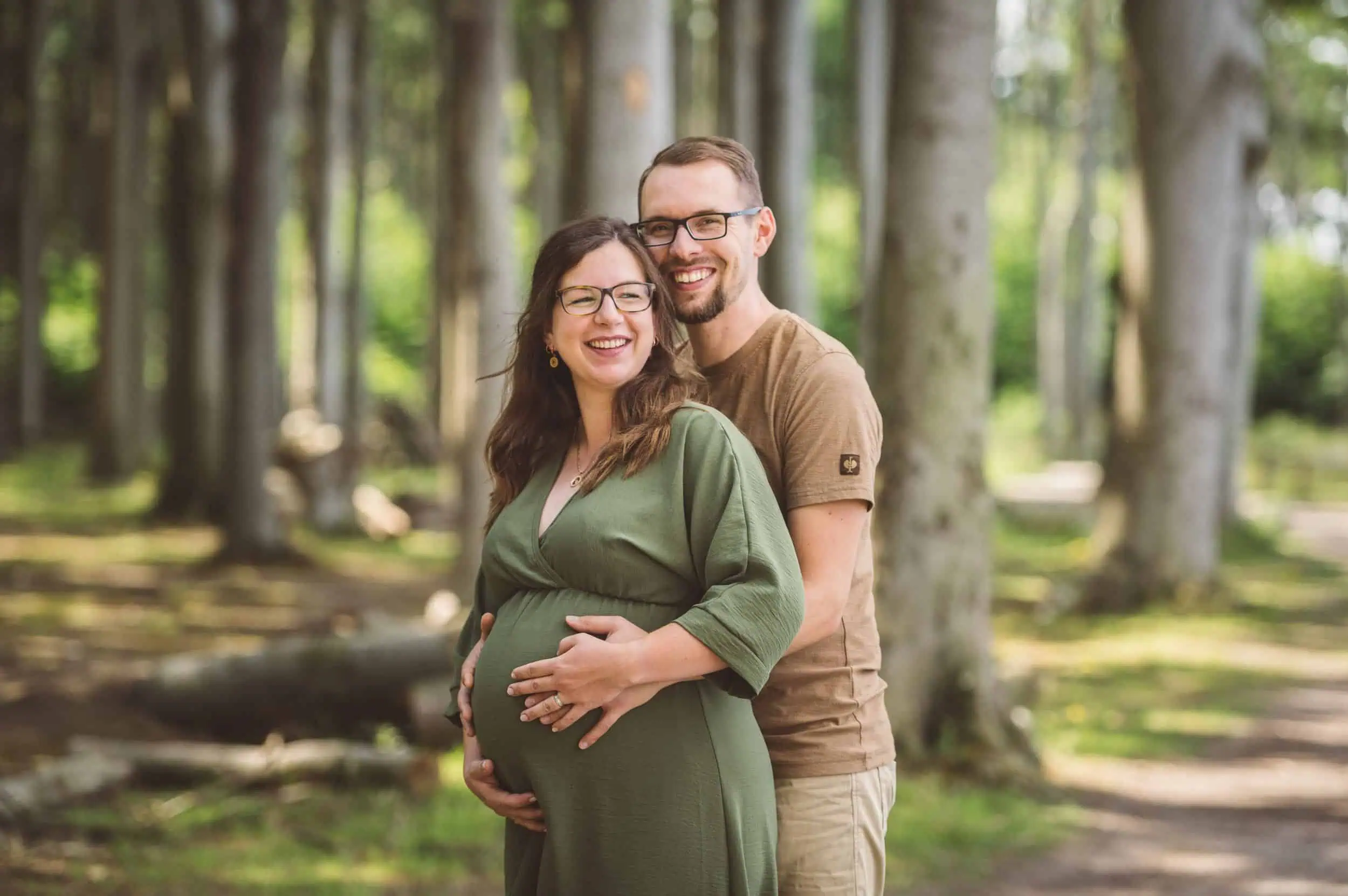 Fotopakete für Paare und Eltern jetzt sichern Glückliches Paar steht während des Babybauch Fotoshooting im Gespensterwald.