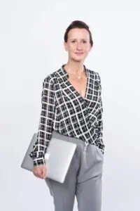 Bewerbungsfotos im Rostocker Fotostudio – Professionelles Business-Porträt einer Frau mit Laptop in stilvollem Outfit vor hellem Hintergrund.
