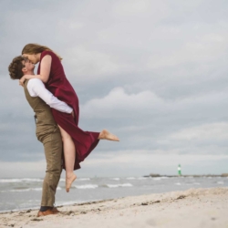 Romantisches Paar küsst sich verliebt am Ostseestrand in Warnemünde vom Hochzeitsfotograf in Warnemünde für immer festgehalten