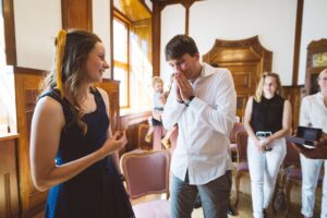 Rührender Moment bei der Ringübergabe – Standesamtliche Trauung im kleinen Saal in Rostock Emotionaler Moment bei der standesamtlichen Trauung im kleinen Saal in Rostock: Der Bräutigam ist überwältigt, während die Braut lächelnd den Ehering hält.