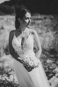 Brautportrait in Markgrafenheide: Braut im Spitzenkleid mit Rosenstrauß in