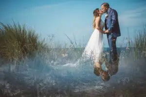 Brautpaar beim Kuss während des Shootings in den Dünen von Markgrafenheide mit Spiegelung im Vordergrund.