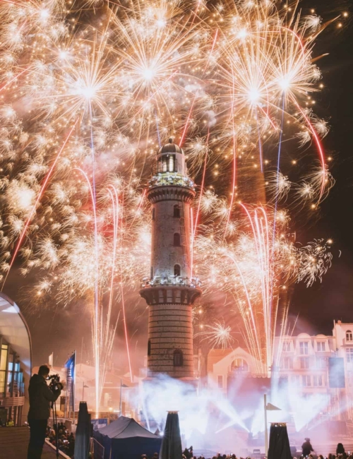 business-fotograf-event–rostock-067 Feuerwerk erleuchtet den Leuchtturm in Warnemünde beim Event Turmleuchten mit farbigen Feuerwerk am Nachthimmel.